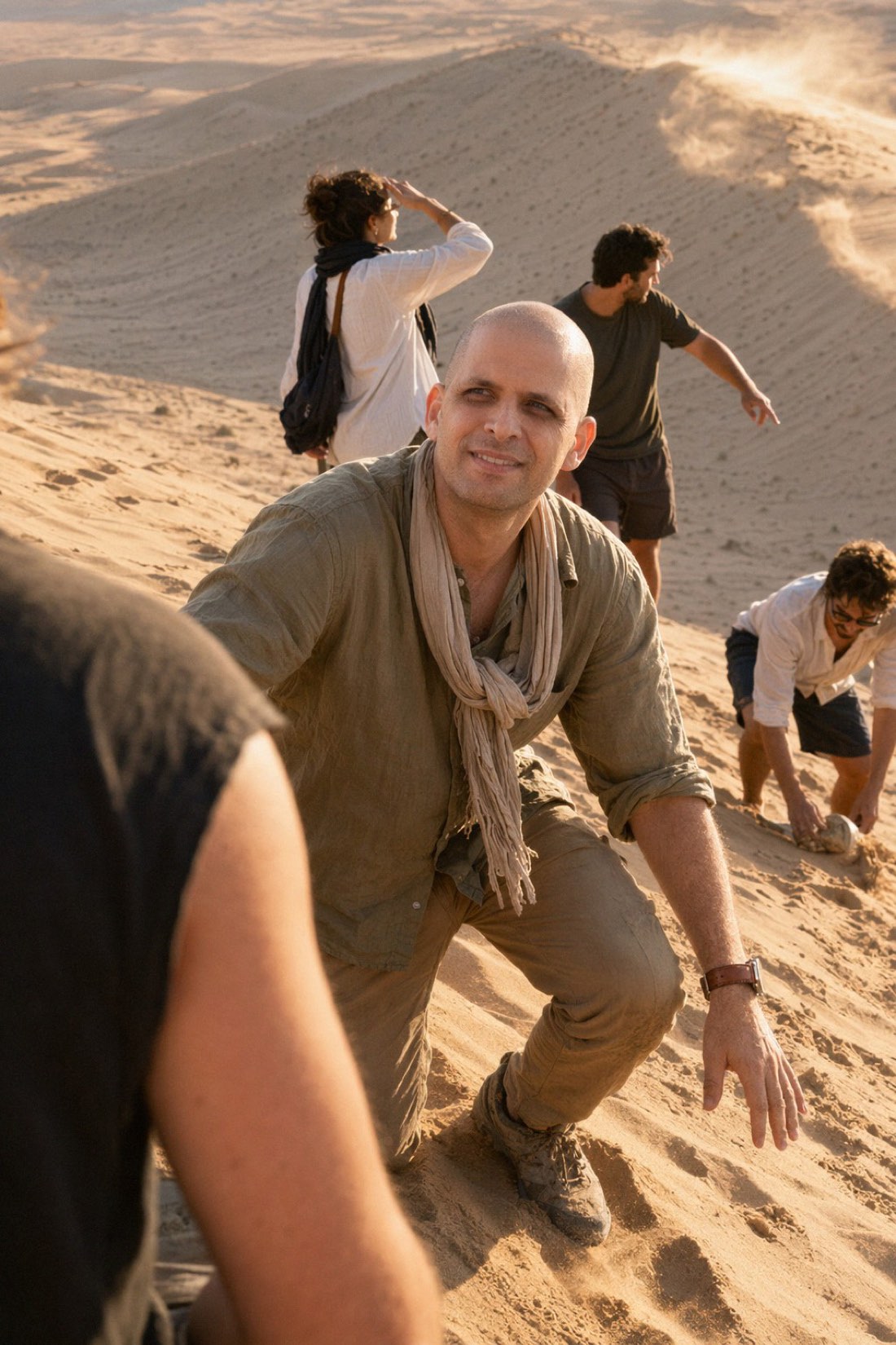 Man on desert sand dunes at golden hour with friends, a realistic AI travel photo
