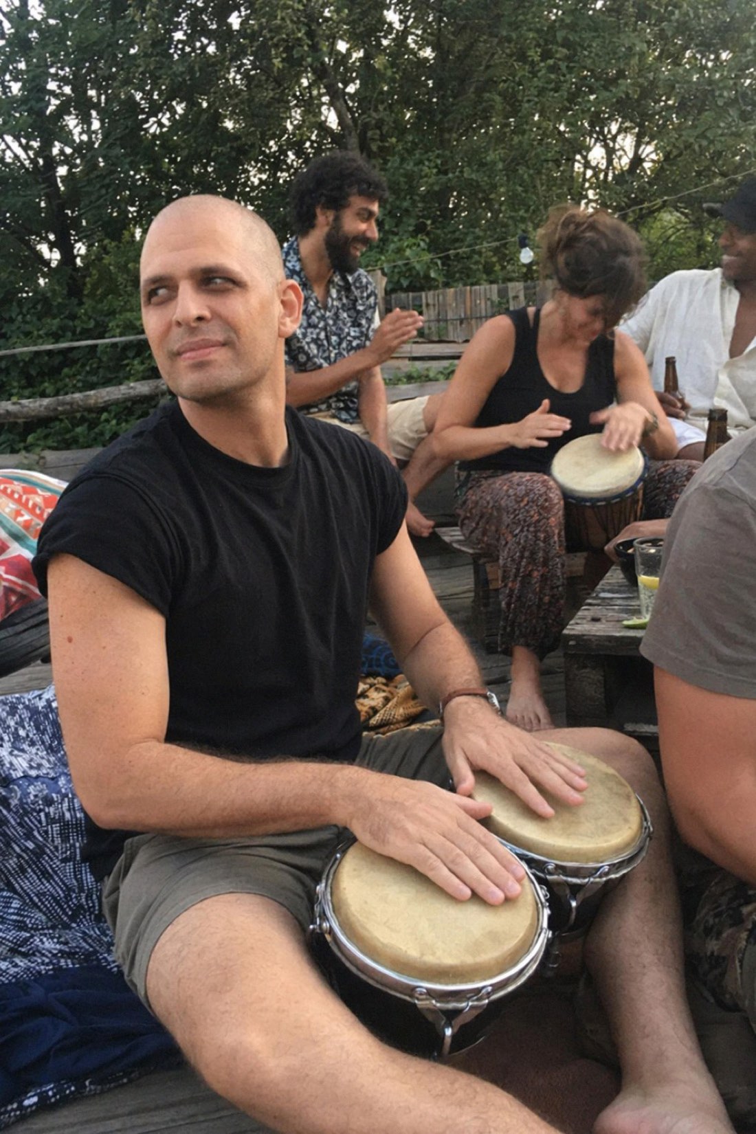 Realistic AI photo of a man playing drums at an outdoor social gathering, generated from his own reference photos