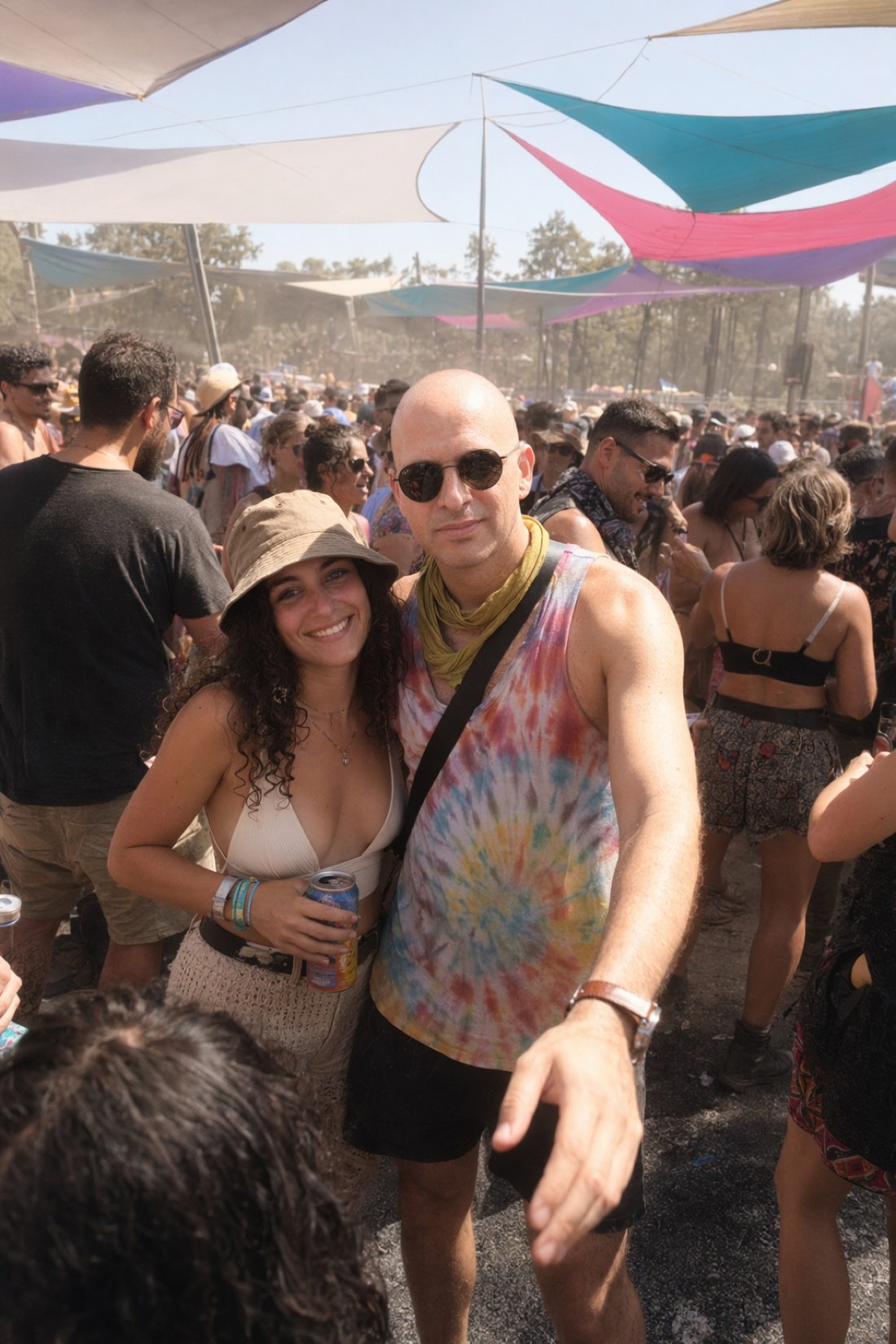Man in a tie-dye top with a friend at the same outdoor festival