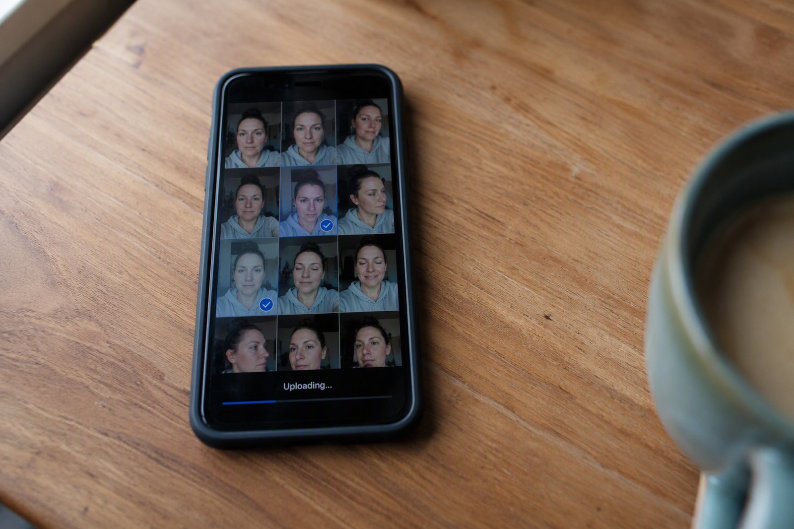 A phone gallery with several selfies selected, mid-upload