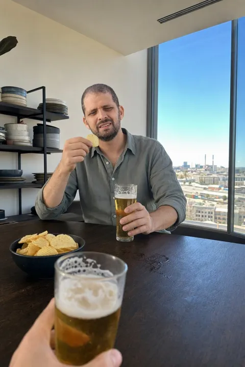 AI dating photo example: with a beer at a window table over the city