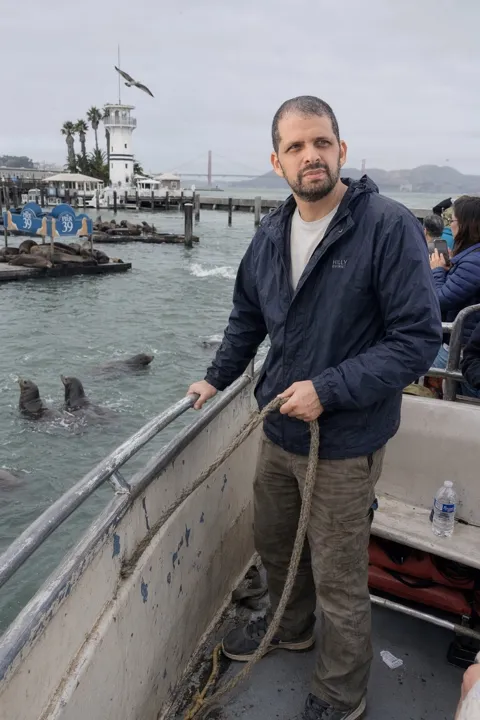 AI dating photo example: on a boat beside a pier of sea lions