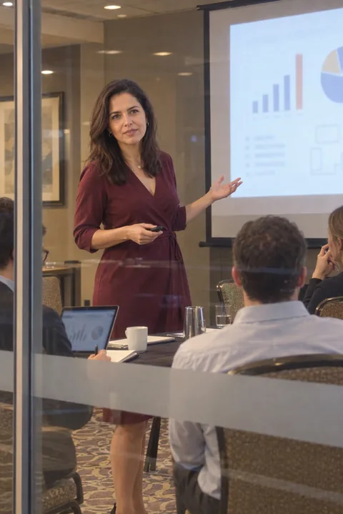 AI LinkedIn photo example: presenting in a hotel conference suite, seen through the glass